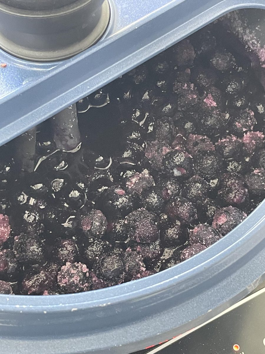 Blueberries and sugar cooking in a stirring cooker